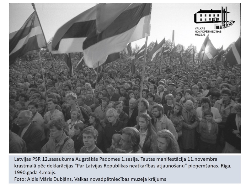 Augstākās padomes deputāti pēc deklarācijas pieņemšanas. Tautas manifestācija 11.novembra krastmalā. Cilvēku pūlis stāv ar Latvijas karogiem.